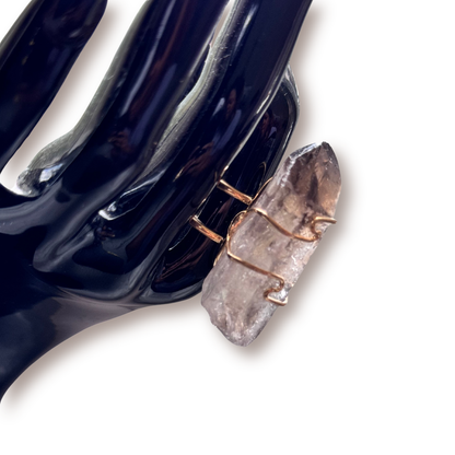 Detail view of gold wire wrapping around the natural facets of the smoky quartz crystal